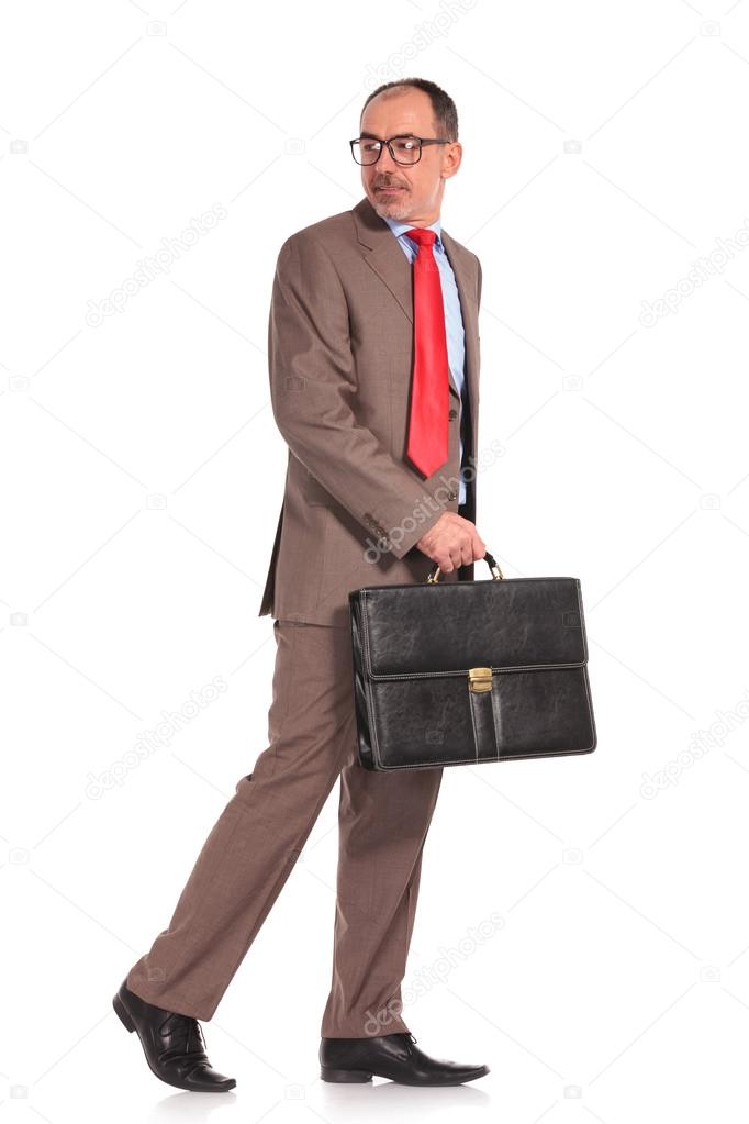 side view of a walking businessman looking back