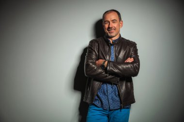 happy senior casual man in leather jacket with hands crossed