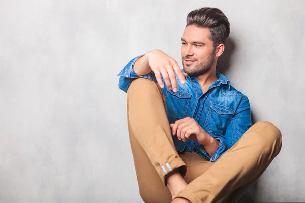 Model sitting in studio legs crossed looking way — Stock Photo, Image