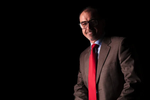 Old business man sitting in studio and smiles — Stock Photo, Image