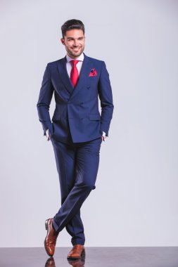 Elleri ceplerinde yaparken bağdaş poz takım elbiseli adam