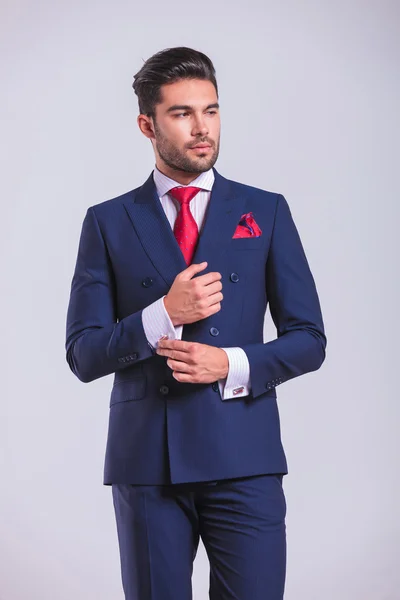 Elegante hombre de traje mirando hacia otro lado mientras desabotonaba la camisa — Foto de Stock