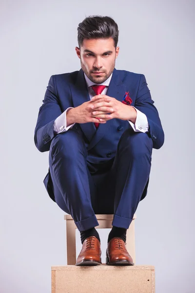 Hombre sentado en una silla con las palmas juntas posando —  Fotos de Stock