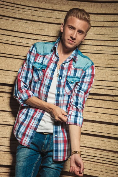 Blonde man poseren in studio terwijl vaststelling van zijn shirt — Stockfoto