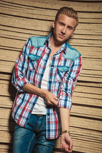 Loira homem posando no estúdio enquanto fixa sua camisa — Fotografia de Stock