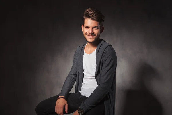 Heureux jeune homme en arrière-plan studio souriant à la caméra — Photo