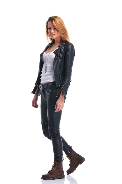 Model pose in leather jacket while walking in studio and looking — Stock Photo, Image