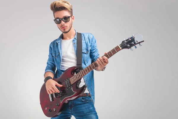 Retrato de un joven guitarrista tocando la guitarra en el estudio — Foto de Stock