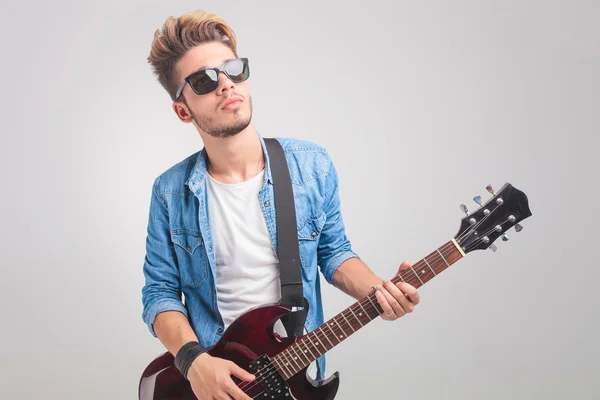 Pessoa tocando guitarra em estúdio enquanto usava óculos de sol — Fotografia de Stock