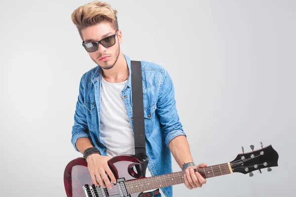 Artista tocando la guitarra en fondo de estudio —  Fotos de Stock