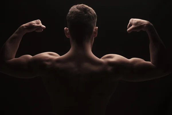Muskulöser Mann, der Arme und Schultern beugt und oben ohne posiert — Stockfoto