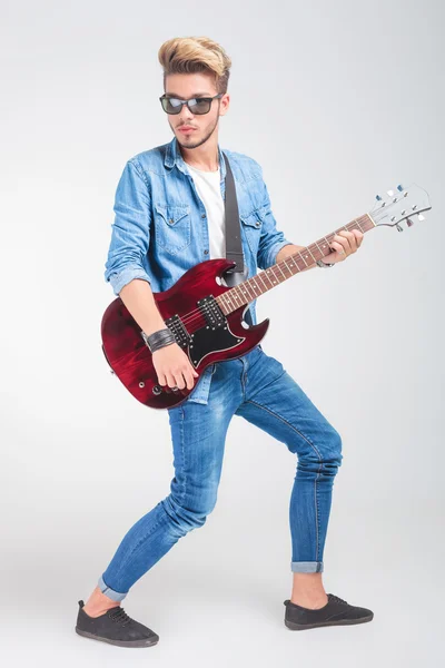 멀리 보고 포즈를 취하는 동안 스튜디오에서 기타를 연주 아티스트 — 스톡 사진
