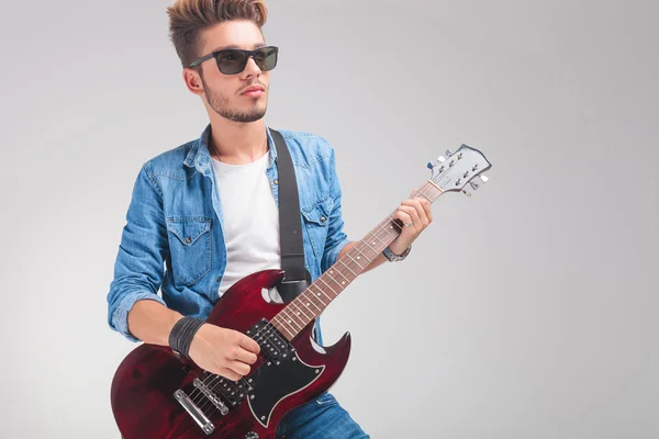 Guy wearing sunglasses while playing the guitar Royalty Free Stock Photos