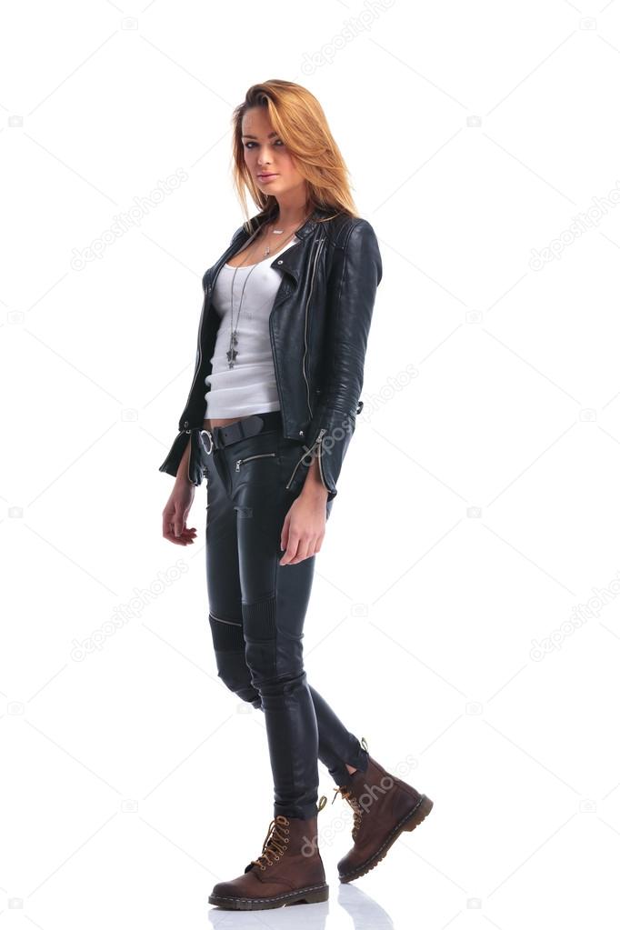 model pose in leather jacket while walking in studio and looking