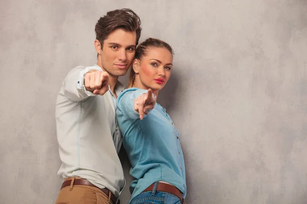 Man and woman standing close and pointing fingers in studio — Stock Photo, Image