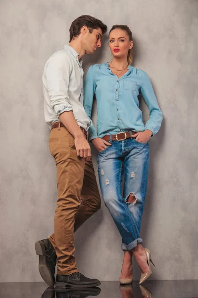 Man op zoek weg terwijl vrouw pose in studio met in zak handen — Stockfoto