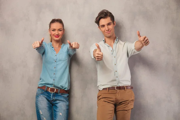 Couple showing both thumbs up in studio background — Stock Photo, Image