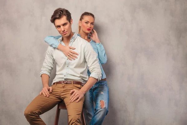Man seated in studio while girfrend stands in the back — Stock Photo, Image