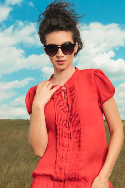 Mujer posando en la naturaleza usando gafas de sol mientras fija su colla —  Fotos de Stock