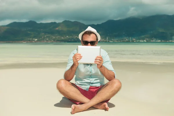 Mann mit Sonnenbrille versteckt sich im Sitzen hinter Tablet — Stockfoto