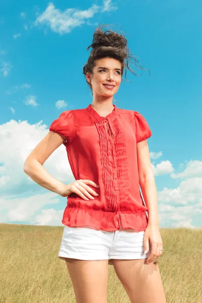 Attractive girl posing in the green fields with hand on her wais — Stock Photo, Image