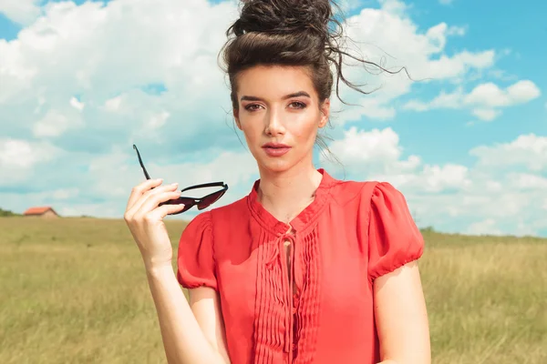 Portrait of young woman taking off her sunglasses — Stock Photo, Image