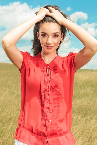 Portrait of woman posing in the fields with her hands fixing her — Stock Photo, Image
