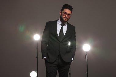 man posing for the camera with hands in pockets in studio 