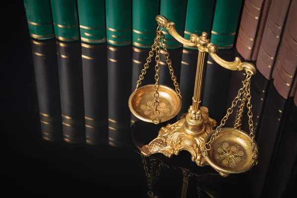 Golden justice scales in front of law books — Stock Photo, Image