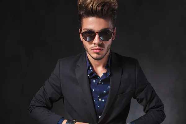 Portrait of young man closing his jacket while posing in dark s — Stockfoto