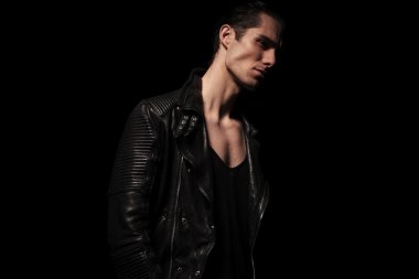 portrait of rocker in black leather posing in dark studio