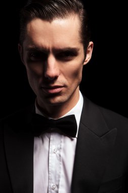 dark portrait of classy man in tuxedo with bowtie 