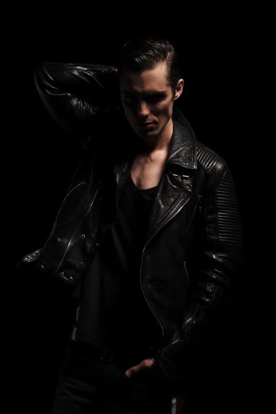 Rocker posing in dark studio with hand in pocket — Stok fotoğraf