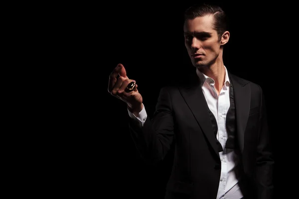 Man in black jacket posing in dark while snapping fingers — Stok fotoğraf