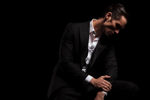 Man in black in dark studio looking down — Stock fotografie