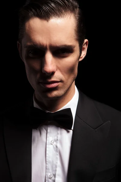 Dark portrait of classy man in tuxedo with bowtie — Zdjęcie stockowe