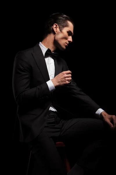 Skinny man in black with bowtie posing in dark studio — Stok fotoğraf