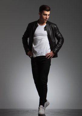 man posing with hands on hips while walking in studio