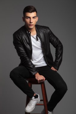 handsome model in leather posing with hand between legs