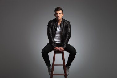 sensual model posing seated with hands between legs