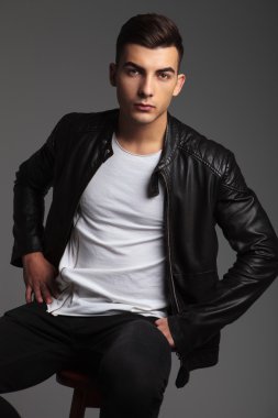 casual man posing seated with hands on waist