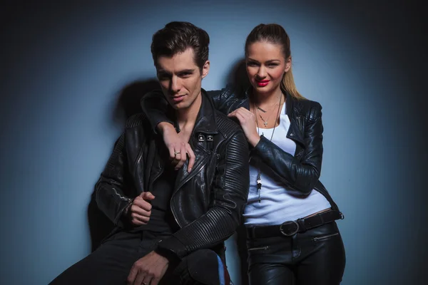 Seated man arranging his jacket while woman rests with hand over — Stock Photo, Image