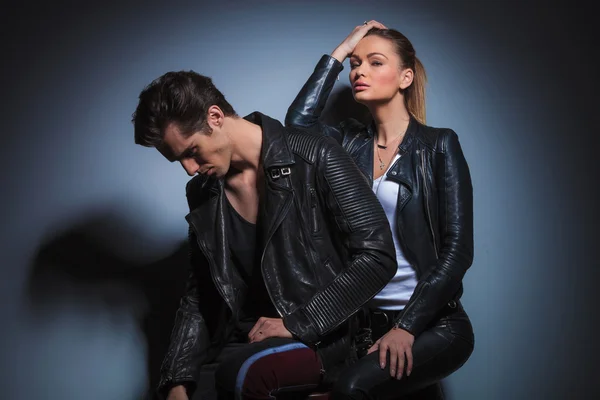 Woman seated behind her man, posing in studio — Stok fotoğraf