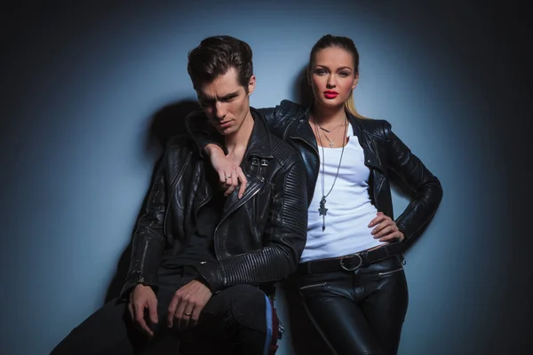 Seated man pose for the camera while woman has her hand around h — Stock Photo, Image