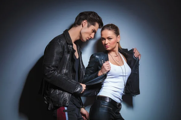 Woman in leather pose in studio while boyfriend takes off her ja — Stock Photo, Image