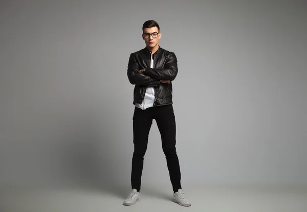 Man in leather jacket posing in studio with hands crossed — Stok fotoğraf