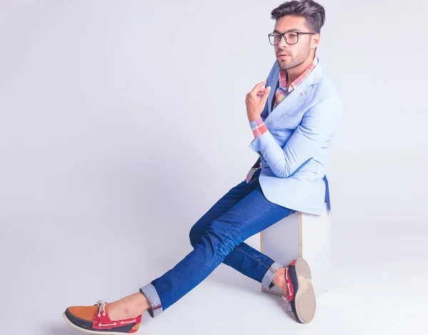 Smart casual man wearing glasses posing seated — Stockfoto