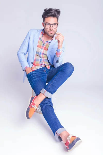 Tipo con gafas y jeans posando sentado — Foto de Stock