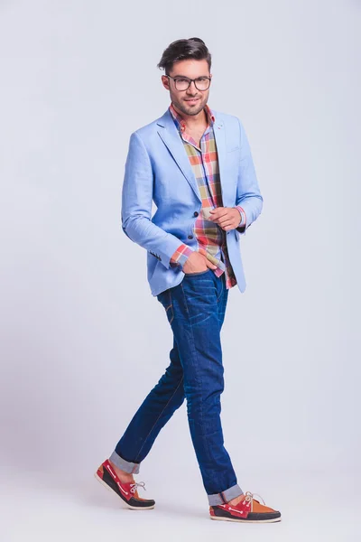 Young man wearing glasses walking in studio — Stock Photo, Image