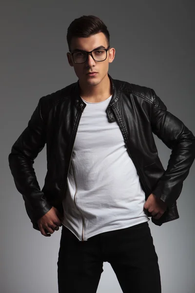 Model wearing glasses in studio fixing his jacket — Stok fotoğraf